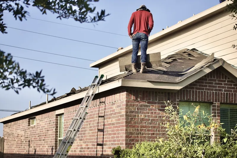 Professional roofer working on a residential roof in Columbiana